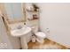 Cozy powder room with pedestal sink, wall shelves, decorative mirror and warm wood-look flooring at 19652 Shadow Trace Path, Westfield, IN 46074