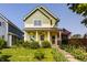 Charming two-story home featuring a covered front porch, lush landscaping, and an American flag at 2020 N Park Ave, Indianapolis, IN 46202