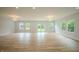 Large, open living room with hardwood floors, windows overlooking the backyard and modern lighting at 2159 W 58Th Nw St, Indianapolis, IN 46228