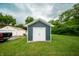Blue shed in a grassy backyard with a white double door at 2159 W 58Th Nw St, Indianapolis, IN 46228