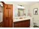 Bathroom featuring double sinks, a large mirror, and wood trim at 2442 N Willow Way, Indianapolis, IN 46268