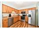 Well-lit kitchen featuring stainless steel appliances, wood cabinets, and vinyl flooring at 2442 N Willow Way, Indianapolis, IN 46268