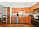 Well-lit kitchen with wood cabinets, stainless steel appliances, and a double basin sink at 2442 N Willow Way, Indianapolis, IN 46268