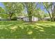 The expansive backyard has mature trees, a wooden fence, and well-kept lawn at 255 N Pasadena Rd, Noblesville, IN 46062