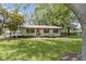 View of cozy one-story home featuring tidy landscaping, shaded by mature trees in front yard at 255 N Pasadena Rd, Noblesville, IN 46062