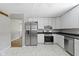 Spacious kitchen with stainless steel refrigerator, white cabinets, marble floors, and a view to the breakfast area at 255 N Pasadena Rd, Noblesville, IN 46062