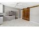 Open concept layout with modern sliding barn door, light gray paint, and marble flooring at 255 N Pasadena Rd, Noblesville, IN 46062