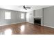 Bright living room with hardwood flooring, stone fireplace, multiple windows, and a ceiling fan at 255 N Pasadena Rd, Noblesville, IN 46062