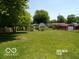 Large, grassy backyard with mature trees and two storage sheds at 26 Crescent Ct, Chesterfield, IN 46017