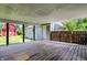 Covered back patio with wood deck, showcasing views of a charming barn and detached garage at 267 S Grant Ave, Indianapolis, IN 46201