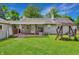 Large backyard with covered patio, swing set, and mature trees perfect for outdoor enjoyment at 267 S Grant Ave, Indianapolis, IN 46201