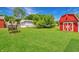 Expansive backyard with lush lawn, a red barn-style shed, and a detached garage at 267 S Grant Ave, Indianapolis, IN 46201