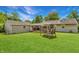 Spacious backyard featuring a covered patio, lush green grass, and a classic swing set at 267 S Grant Ave, Indianapolis, IN 46201