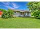 Charming single-story home featuring a well-maintained lawn and mature trees under a bright blue sky at 267 S Grant Ave, Indianapolis, IN 46201