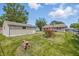 Backyard with grassy lawn, detached garage, and small trees and shrubs at 2908 N Routiers Ave, Indianapolis, IN 46219