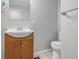 Clean bathroom with a wood vanity, modern sink, new toilet, and a well-lit mirror at 2908 N Routiers Ave, Indianapolis, IN 46219