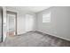 Bedroom featuring soft gray carpet, closet, and a sunny window with a view to the exterior at 2908 N Routiers Ave, Indianapolis, IN 46219