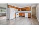 Functional kitchen with wood cabinets, white appliances, and modern gray vinyl flooring at 2908 N Routiers Ave, Indianapolis, IN 46219