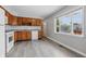 Open kitchen features modern vinyl floors, wood cabinets, and ample natural light from the window at 2908 N Routiers Ave, Indianapolis, IN 46219