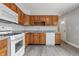 Well-lit kitchen equipped with white appliances, wood cabinetry, and sleek countertops at 2908 N Routiers Ave, Indianapolis, IN 46219