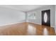 Bright living room featuring hardwood floors, a large window, fresh paint, and a stylish front door at 2908 N Routiers Ave, Indianapolis, IN 46219