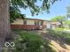 Brick and vinyl home featuring mature tree and green lawn at 3106 Southwest Dr, Indianapolis, IN 46241