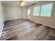 Open-concept living room featuring wood-look floors and view of backyard at 3106 Southwest Dr, Indianapolis, IN 46241