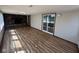 Spacious living room with brick fireplace, updated floors, and sliding glass door to outdoor space at 3155 Roseway Dr, Indianapolis, IN 46226