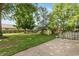 Spacious backyard featuring mature trees, a play set, and a patio area at 3225 25Th St, Columbus, IN 47203