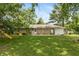 Spacious backyard with a well-maintained lawn, play area, and mature trees offering shade and privacy at 3225 25Th St, Columbus, IN 47203