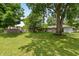 Large backyard with mature trees, play set, and ample space for outdoor activities and relaxation at 3225 25Th St, Columbus, IN 47203