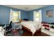 Bedroom features hardwood floors, blue walls, a bed, and a desk at 3225 25Th St, Columbus, IN 47203