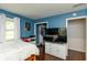 A bedroom featuring hardwood floors, blue walls, bed, and a tv at 3225 25Th St, Columbus, IN 47203