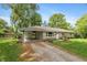 Charming single-story home with a gravel driveway, lush lawn, and mature trees providing shade and curb appeal at 3225 25Th St, Columbus, IN 47203