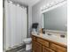 Bathroom with white shower curtain, wood vanity, and standard lighting at 3620 N Lakeside Dr, Muncie, IN 47304