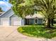Charming home with light blue siding, attached garage, and mature shade tree in a well-kept neighborhood at 3620 N Lakeside Dr, Muncie, IN 47304
