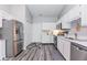 Well-lit kitchen featuring stainless steel appliances, white cabinets, and modern gray flooring at 3620 N Lakeside Dr, Muncie, IN 47304