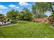 Lush backyard with large grassy area, garden beds, mature trees, and privacy fence at 3916 St Simons Ct, Indianapolis, IN 46237