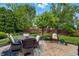 Charming backyard patio with dining area, complemented by well-manicured lawn and vibrant landscaping at 3916 St Simons Ct, Indianapolis, IN 46237