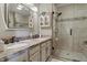 Bathroom featuring double sinks, granite countertops, vanity, and a glass-enclosed shower with tiled walls at 3916 St Simons Ct, Indianapolis, IN 46237