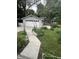 Backyard featuring a detached garage, garden beds, and well-maintained grass at 4619 N Park Ave, Indianapolis, IN 46205
