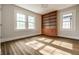 Sunlit bedroom featuring hardwood floors, built-in bookcase, and windows with light streaming in, offering a cozy space at 4619 N Park Ave, Indianapolis, IN 46205