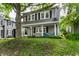 Traditional home with a covered porch, featuring classic shutters and a mature tree in the front yard at 4619 N Park Ave, Indianapolis, IN 46205