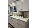 Bright kitchen featuring white cabinets, quartz countertops, tiled backsplash, and modern gold hardware at 4619 N Park Ave, Indianapolis, IN 46205