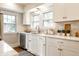 Well-lit kitchen featuring white cabinets, modern hardware, a stainless steel dishwasher, and a tiled backsplash at 4619 N Park Ave, Indianapolis, IN 46205