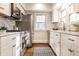 Bright kitchen showcasing white cabinetry, stainless steel appliances, and a stylish rug on gleaming hardwood floors at 4619 N Park Ave, Indianapolis, IN 46205