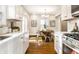 Open kitchen view leading into dining area with wood table, highlighting stainless steel appliances and white cabinetry at 4619 N Park Ave, Indianapolis, IN 46205