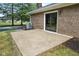 Concrete patio adjacent to brick home's rear exterior with sliding glass doors at 4645 Quail Run Dr, New Palestine, IN 46163