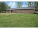 The home's rear exterior features brick construction, a small patio, and a spacious lawn at 4645 Quail Run Dr, New Palestine, IN 46163