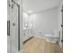 Modern bathroom with a glass shower enclosure, wood-look flooring, and vanity with sleek fixtures and a mirror at 4645 Quail Run Dr, New Palestine, IN 46163